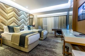 巴勒克埃西尔Willmont Hotel的酒店客房配有两张床和一张书桌