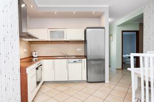 什切青SAS Apartamenty New Park的厨房配有白色橱柜和不锈钢冰箱