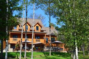 Saint-Rémi-dʼAmherstSelenia Lodge- Résidences et Chalets dans les Laurentides的圆木房子,带围栏门廊