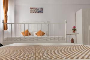 北马马亚-讷沃达里Studio Ambiance , Mamaia的白色卧室配有带橙色枕头的床