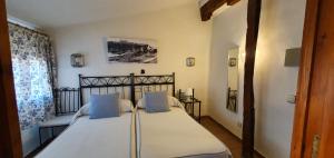 托莱多拉坡萨达得可多维旅馆的一间卧室配有一张带蓝色枕头的大床