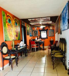 马那瓜拉波萨达德尔阿康热尔住宿加早餐旅馆的坐在钢琴里,在橙色墙壁的房间里,一个女人