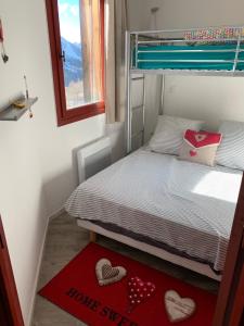 伊索拉2000Appartement de vacances à Isola 2000的一间小卧室,配有一张位于地板上的心床