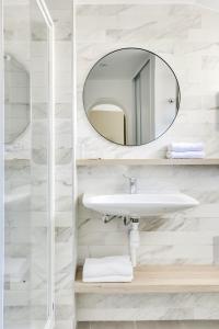 库尔布瓦Hotel Courseine的一间带水槽和镜子的浴室