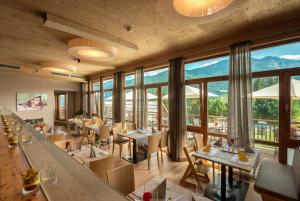 黑马戈尔Familienresort & Kinderhotel Ramsi的餐厅设有桌椅和大窗户。