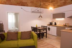 帕拉莫斯Can Pauet Apartaments的客厅以及带沙发和桌子的厨房。