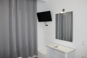 伊莱恩Zeus Hotel的一间带电视和浴帘的浴室