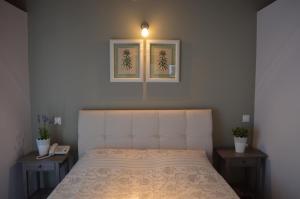 阿索斯浪漫曲一室公寓酒店的一间卧室配有一张带两张桌子和一盏灯的床