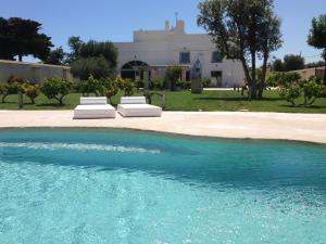 蒙塔尔巴诺马塞里亚安雪拉酒店的房屋前设有一座带两把躺椅的游泳池