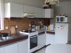根特GUESTROOMS BIJ HET STATION VAN DRONGEN的厨房配有白色橱柜和炉灶烤箱。