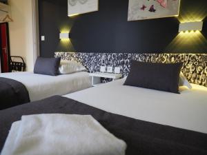 维希Hôtel Le Biarritz - Vichy的酒店客房设有两张床和两盏灯。