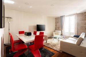 圣地亚哥－德孔波斯特拉Luxury apartment-free parking的客厅配有白色桌子和红色椅子