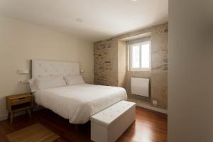圣地亚哥－德孔波斯特拉Luxury apartment-free parking的卧室配有白色的床和窗户。