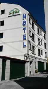帕拉斯德丽Hotel Casa Benilde的一座白色的建筑,上面标有酒店标志