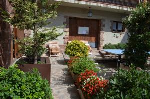 普拉德CAN LLORENÇ的庭院设有桌子和一些植物和鲜花
