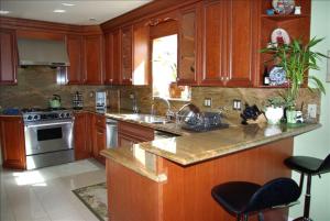 圣布鲁诺Luxury 5 Bedroom Home near SFO的厨房配有木制橱柜和不锈钢用具