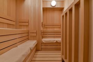 千叶Vessel Inn Chiba Ekimae的一间带木制橱柜和两张床的桑拿浴室
