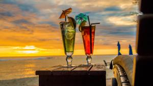 拉罗汤加马努娅海滩度假村的坐在海滩上桌边的两杯饮料