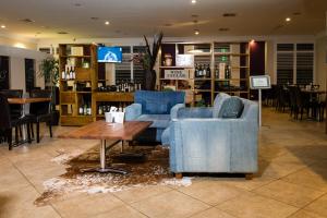 珀斯金合欢树林汽车旅馆的大堂设有2把蓝色椅子和咖啡桌