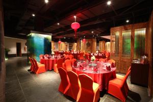 三亚三亚湾红树林度假世界椰林酒店的宴会厅配有红色桌子和橙色椅子