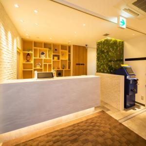 十和田Super Hotel Towada Natural Hot Springs的大堂的收银台,带付费电话