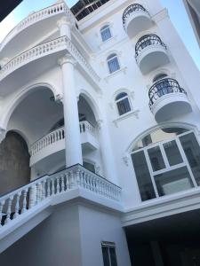 Ðưc TrọngNgoc Lan Hotel and Coffee的一座白色的建筑,设有阳台和楼梯