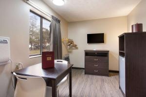 奥拉西Red Lion Inn & Suites Olathe Kansas City的一间设有桌子的房间和一间带电视的厨房