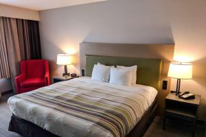 斯莱德尔Comfort Inn & Suites的酒店客房设有一张大床和一张红色椅子。