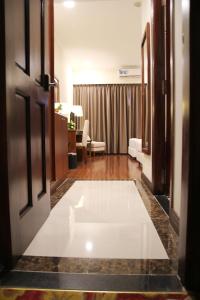 胡志明市同庆酒店的客厅的地板上铺有白色大地毯。