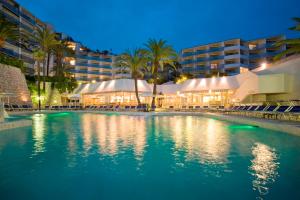 戛纳Hotel Cannes Montfleury的夜间在酒店前的游泳池