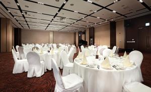 西归浦市济州岛阳光公园酒店的一间设有桌椅和白色桌布的房间