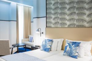 丰沙尔卡什塔涅鲁精品酒店的配有一张床和一把椅子的酒店客房