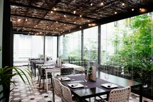 马德里珀蒂宫圣巴巴拉高科技酒店的餐厅设有桌椅和大窗户。