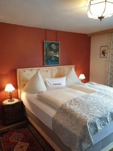 Höfen埃斯侯阿马特酒店的卧室设有一张大床,拥有红色的墙壁