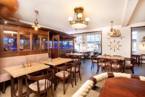奥斯赛拜-塞林瓦尔德弗里顿别墅酒店的餐厅设有木桌、椅子和窗户。