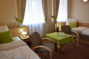 伊诺弗罗茨瓦夫Willa Ostoja的酒店客房带两张床和一张桌子以及椅子。