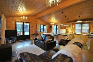 罗厄德南Ben Lomond Lodge的一间带真皮沙发的客厅和一间厨房