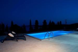 梅加尼西岛Nema Villas的游泳池旁的2把椅子