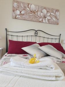 卡斯泰尔莫拉Casa "Rocca di Mola"的一张带红色枕头的床和黄色鸭子