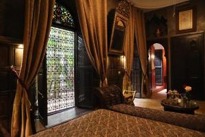 马拉喀什利雅得艾雷亚卡酒店的一间卧室设有一张床和一个大窗户