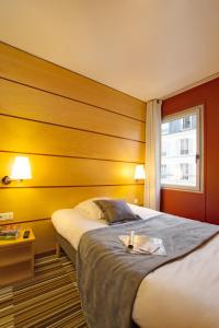巴黎贝朗布阿城市酒店的酒店客房设有床和窗户。