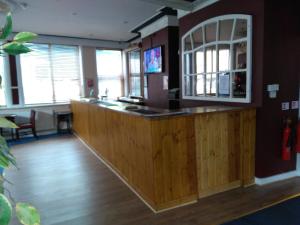 特伦特河畔斯托克王冠酒店的一间酒吧,位于带木地板和窗户的客房