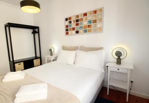 里斯本塞特里奥斯公寓，靠近动物园里斯本/免费无线网络的一间卧室配有白色的床、两张桌子和镜子