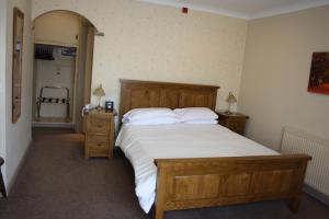 波克灵顿The Feathers的卧室配有一张带白色床单和枕头的大床。