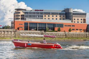 克拉科夫Qubus酒店的建筑物前水中的红船