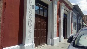 特鲁希略Hostal Virrey & Tours的街道边的建筑,带有棕色门