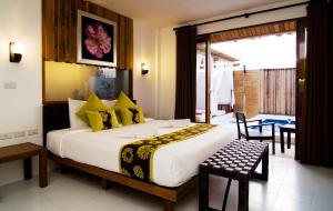 盼武里拉瓦纳爱斯基普酒店的一间卧室配有一张带黄色枕头的大床