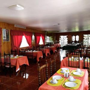 瓦拉斯科隆巴酒店的餐厅配有桌椅和红色桌布