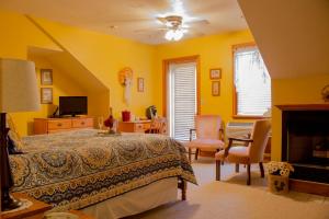 盖茨堡Inn at Herr Ridge的一间卧室设有黄色的墙壁、一张床和电视