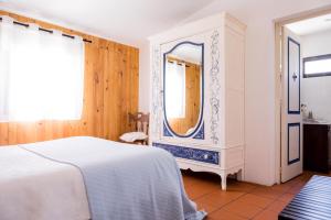 埃武拉Carrança Lounge的卧室配有白色的床和镜子
